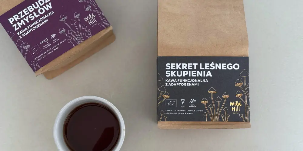 Kawy z grzybami Wild Hill Coffee – Przebudzenie Zmysłów i Sekret Leśnego Skupienia – obok filiżanki czarnej kawy